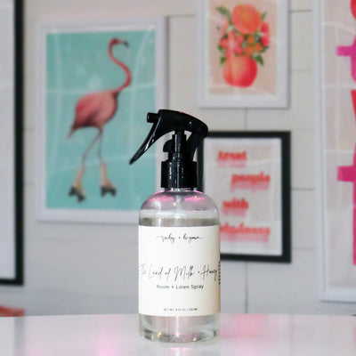 Room & linen spray bottle with a cream colored label, titled 'The Land of Milk & Honey'.
