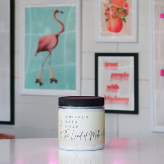 Jar of whipped bath soap with a cream colored label, titled 'The Land of Milk & Honey'.