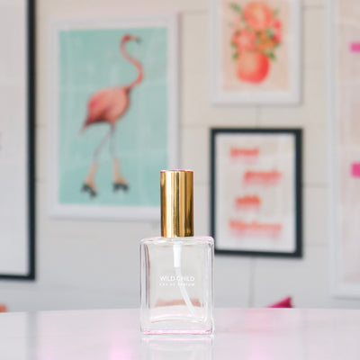 Clear perfume bottle with gold cap, labeled Wild Child.