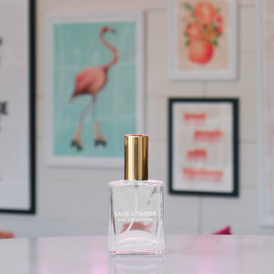 Clear glass perfume bottle with a gold cap, labeled 'Sage & Timber'.