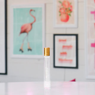 Clear glass rollerball perfume with gold cap, labeled 'The Scarlett'. 
