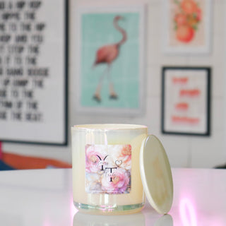 Candle with a floral label with the name Yours Truly on a table.