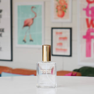 Clear perfume bottle with gold cap labeled Yours Truly.
