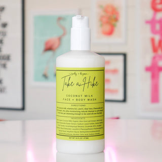 Bottle of coconut milk face & body wash with a green label, titled 'Take a Hike'. 