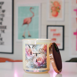 Candle with a floral label with the name Yours Truly on a table
